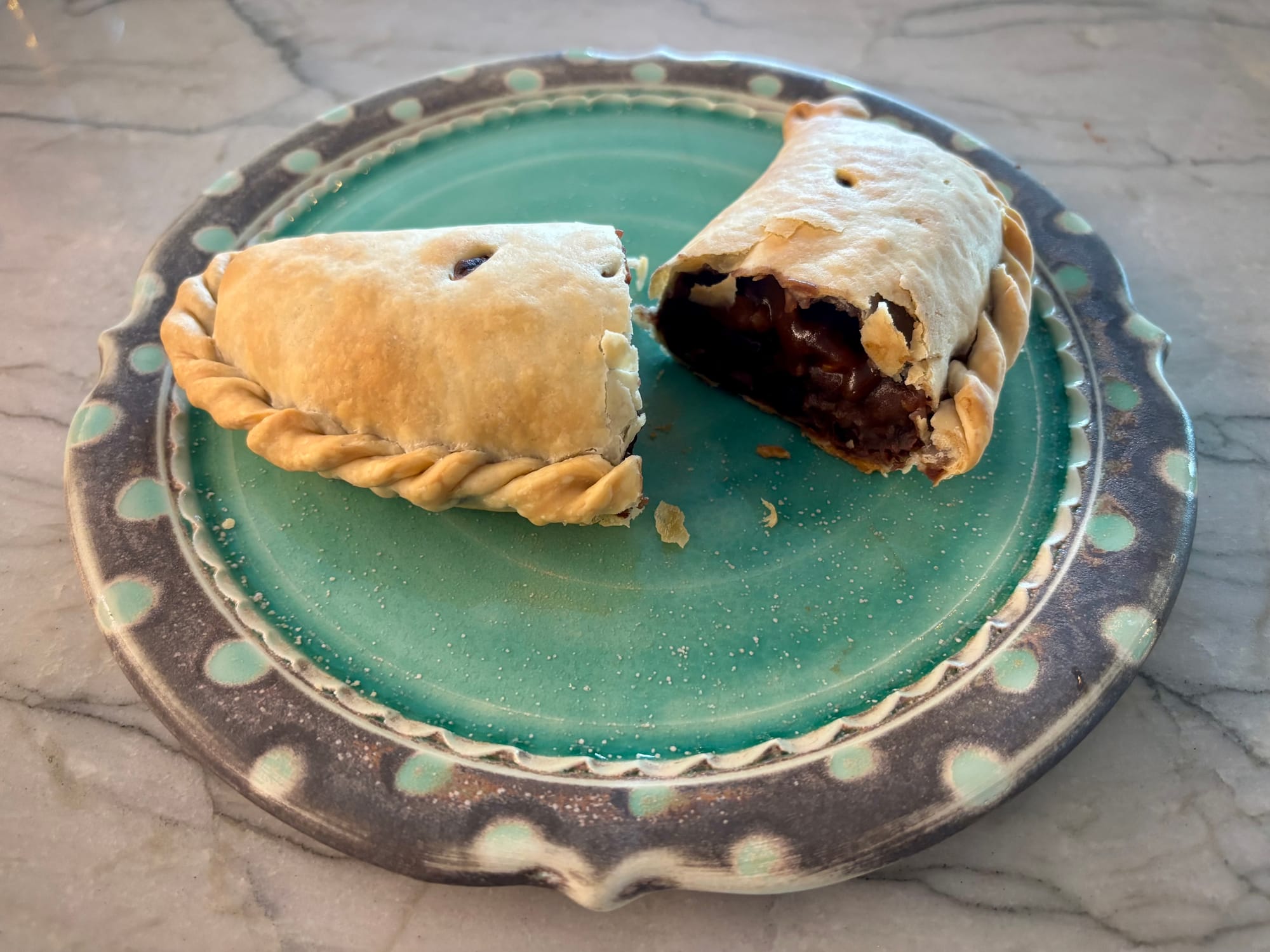 An empanada, cut in half, on a plate