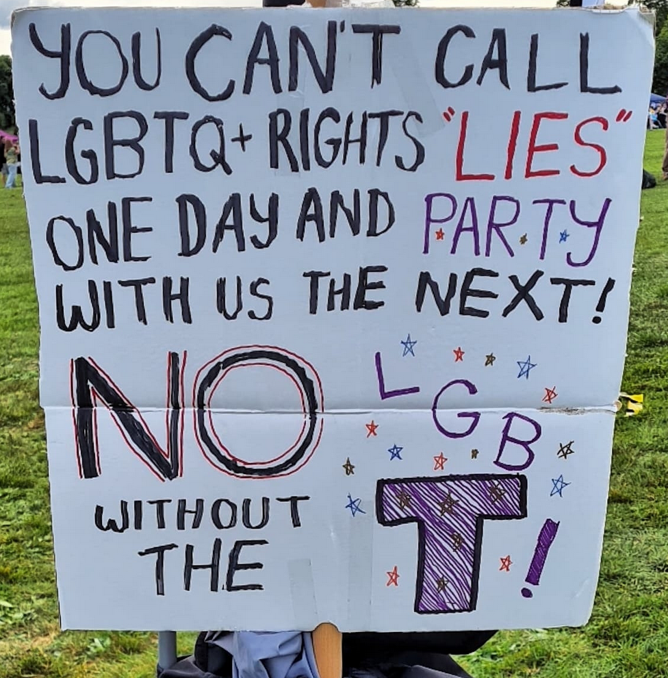 A cardboard sign reading "You can't call LGBTQ+ rights 'lies' one day and party with us the next! No LGB without the T!"