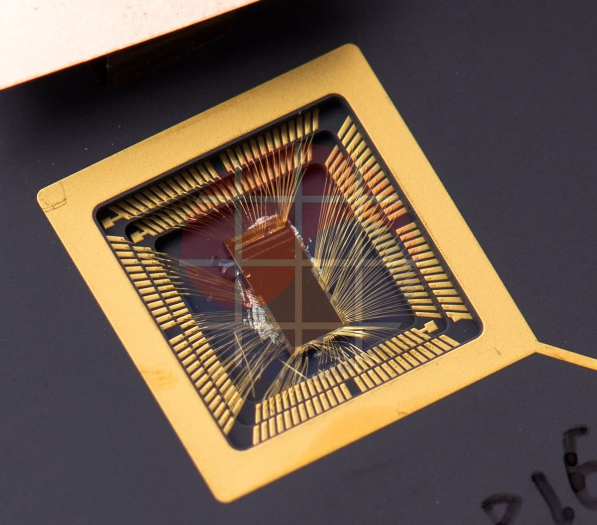 An exposed RISC-V prototype die with bond wires in a gold-colored package, photographed in 2013.