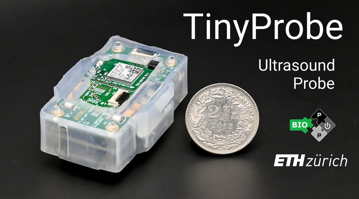 TinyProbe ultrasound research platform with its circuit boards in a transparent enclosure beside a coin