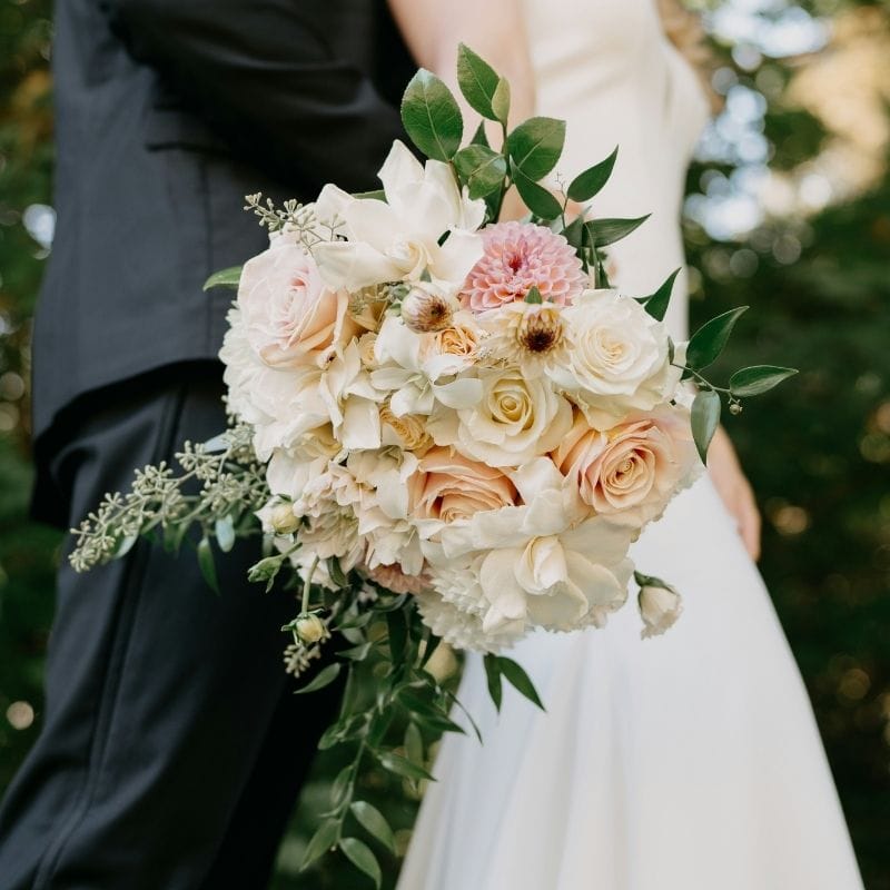 Bride holds a Classic Romance wedding bouquet with peach roses, a perfect style for a Naples, FL wedding at Vineyards Country Club.