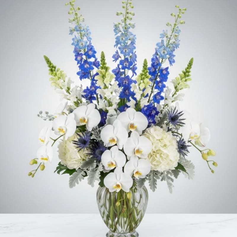 Elegant blue and white Hanukkah centerpiece with roses and delphinium, designed by Grace & Blooms luxury florist in Naples, Florida.