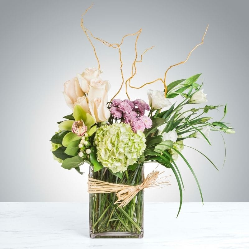 The Continental luxury floral arrangement from Grace & Blooms in Naples, FL, with white roses, green hydrangea, and a cymbidium orchid.