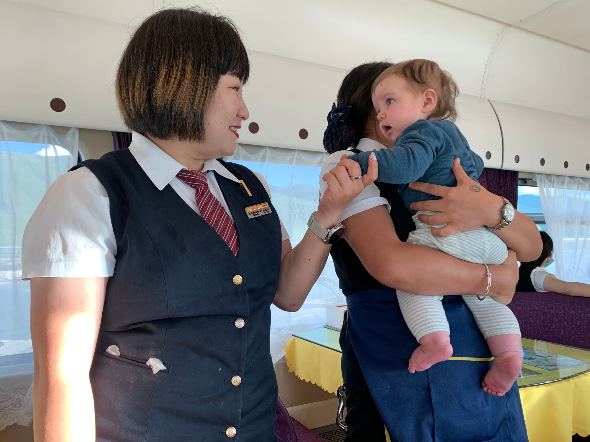 Restaurant carriage staff playing with our toddler on the Qinghai-Tibet Railway