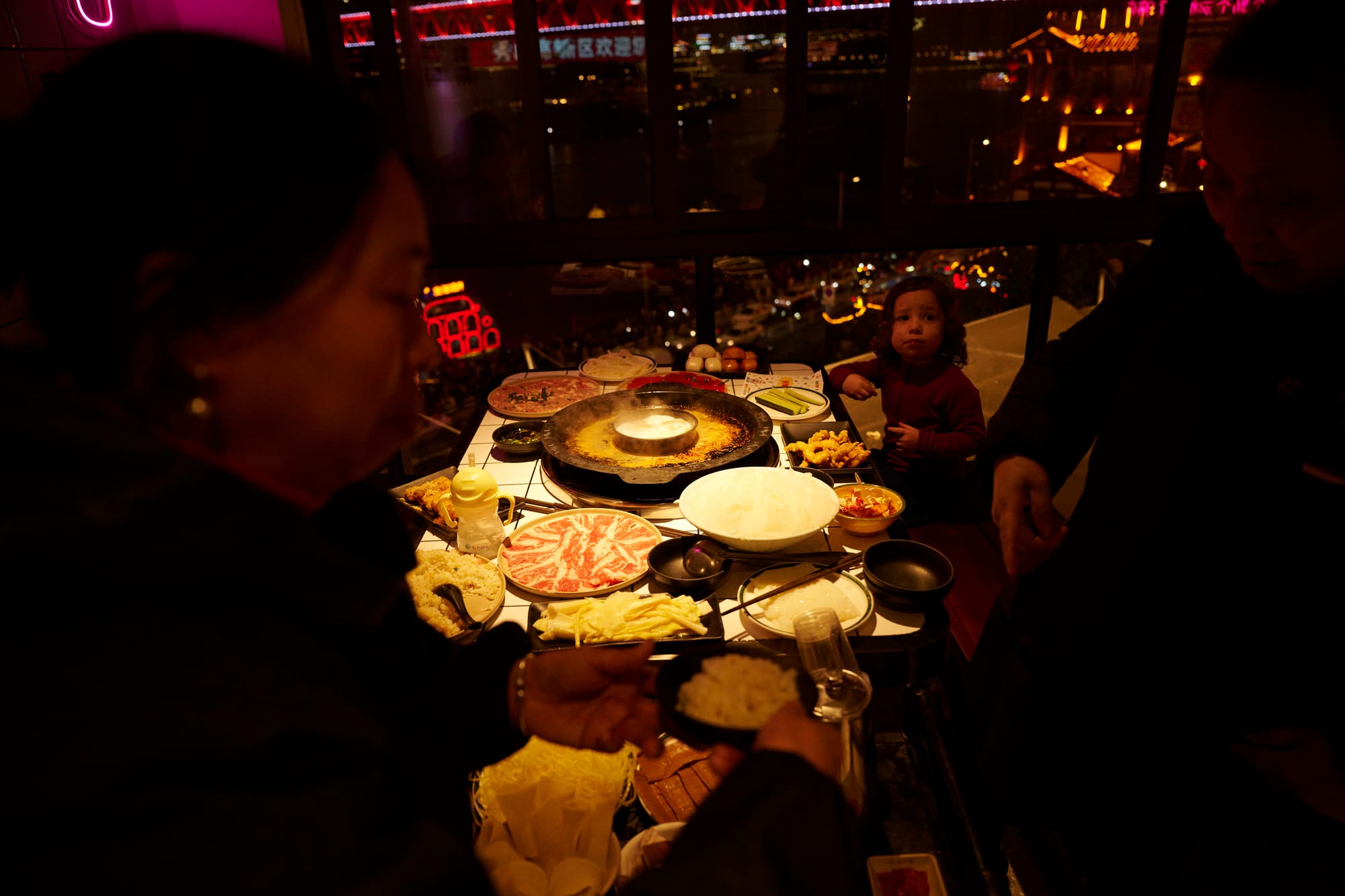 Bubbling Chongqing hot pot with split broth — spicy red on one side, mild clear broth on the other