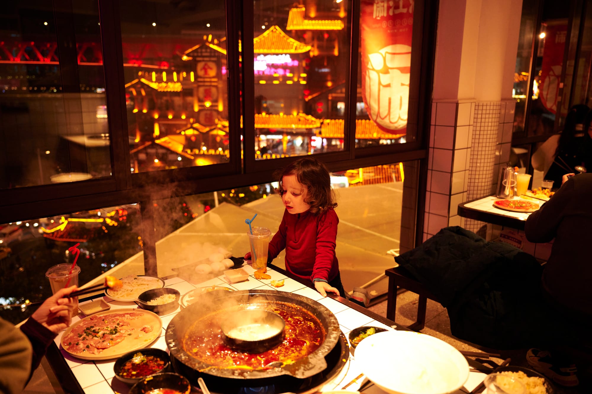 Happy family gathered around a Chongqing hot pot table, enjoying the meal together