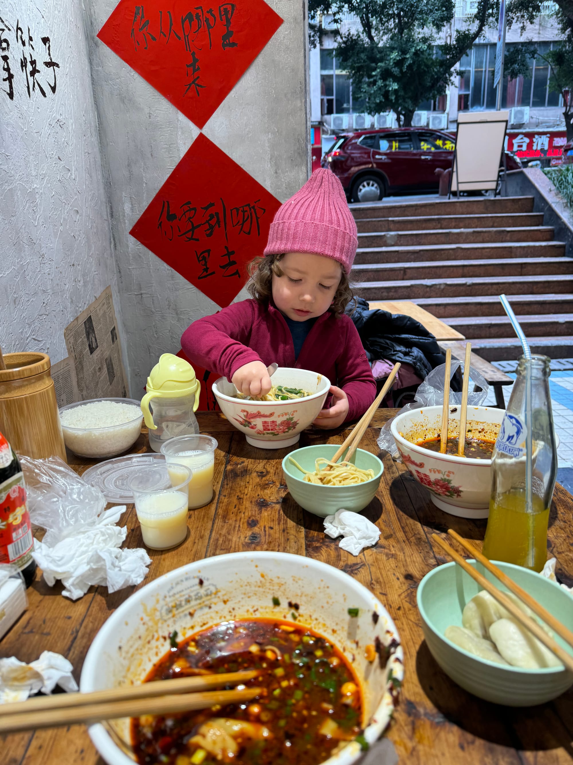 Family enjoying street BBQ skewers at an outdoor food stall in China