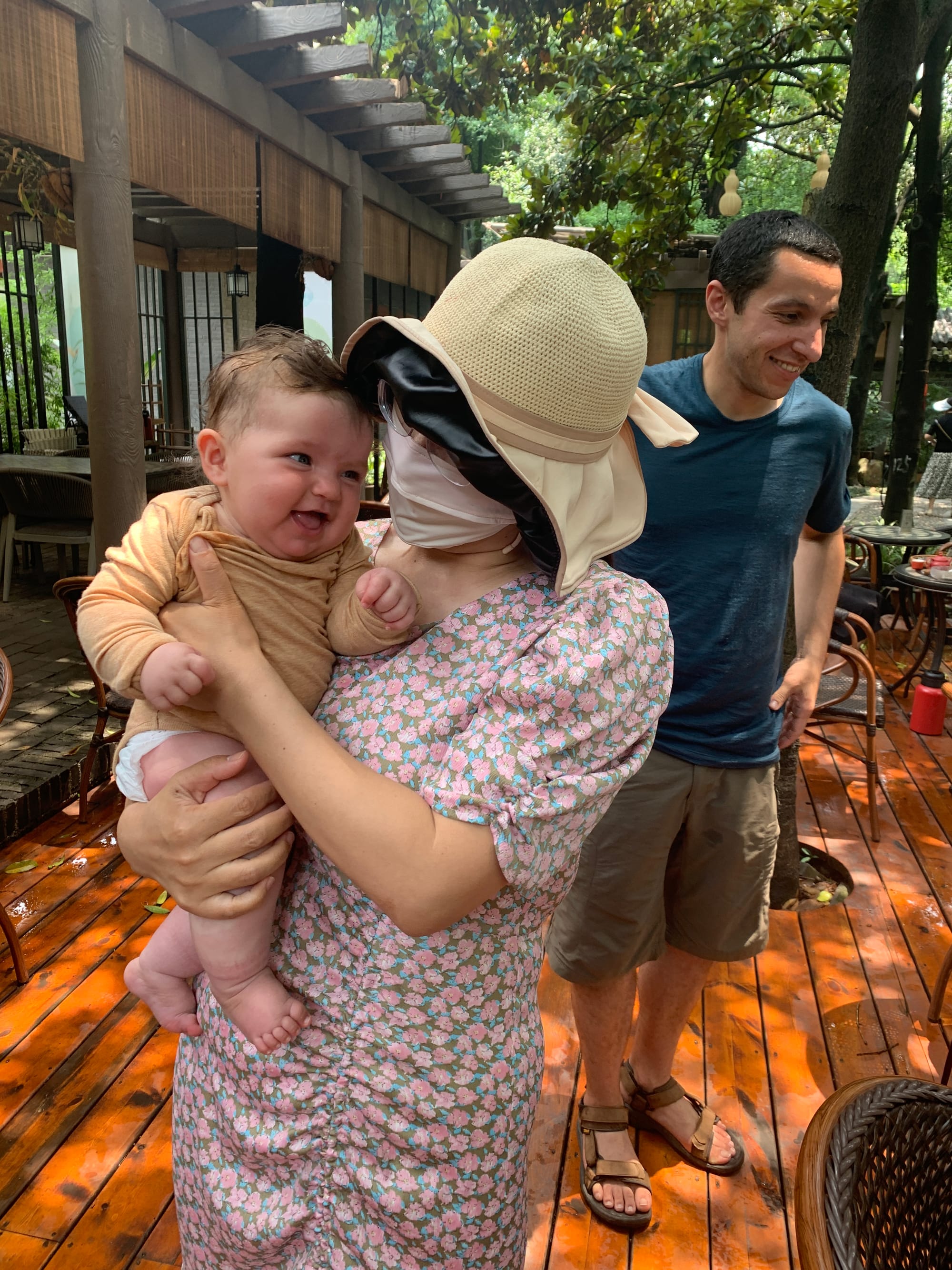 Nina held by a stranger in a teahouse in Chengdu