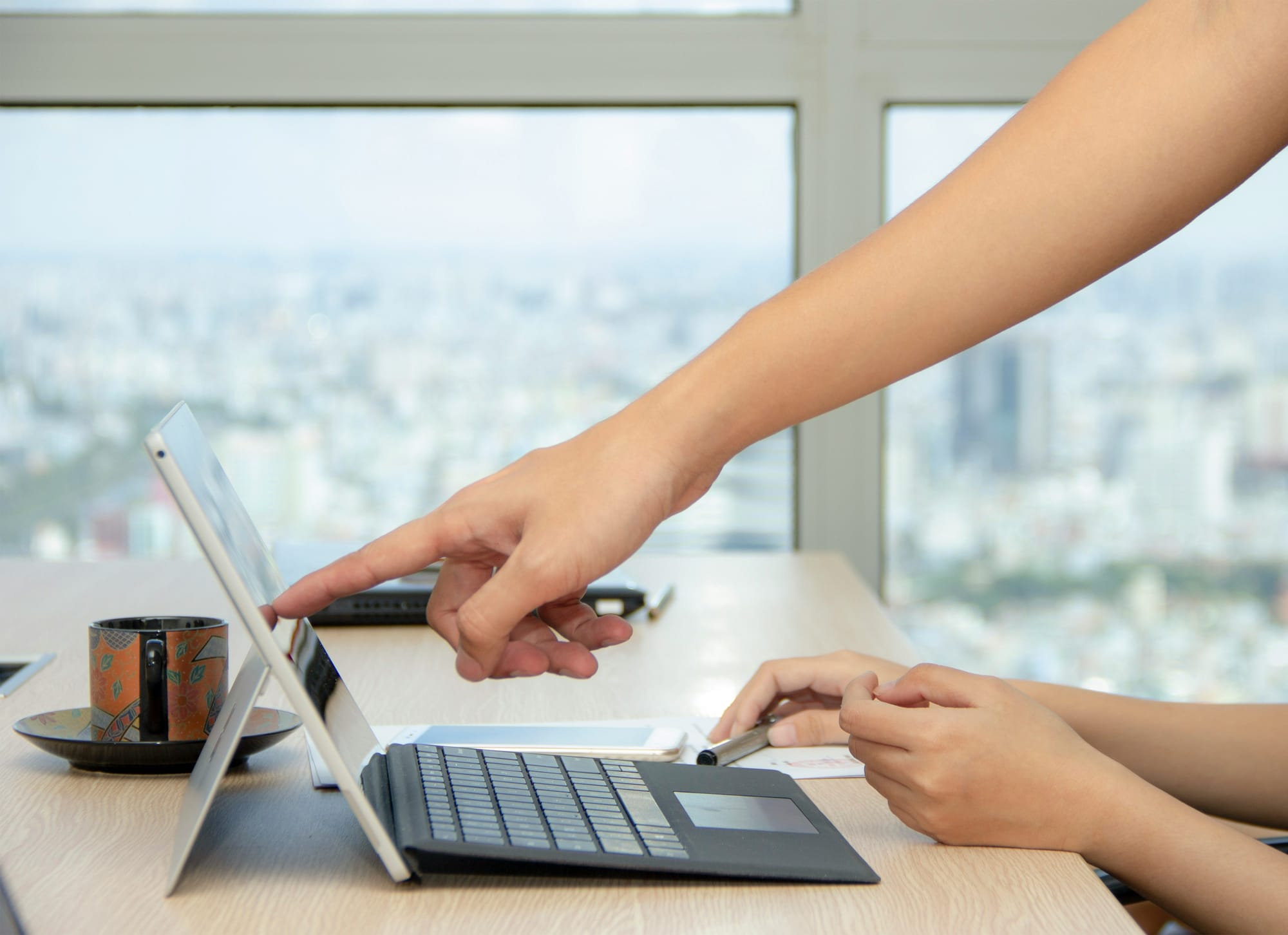 woman showing coworker on laptop - free ai tools for marketing
