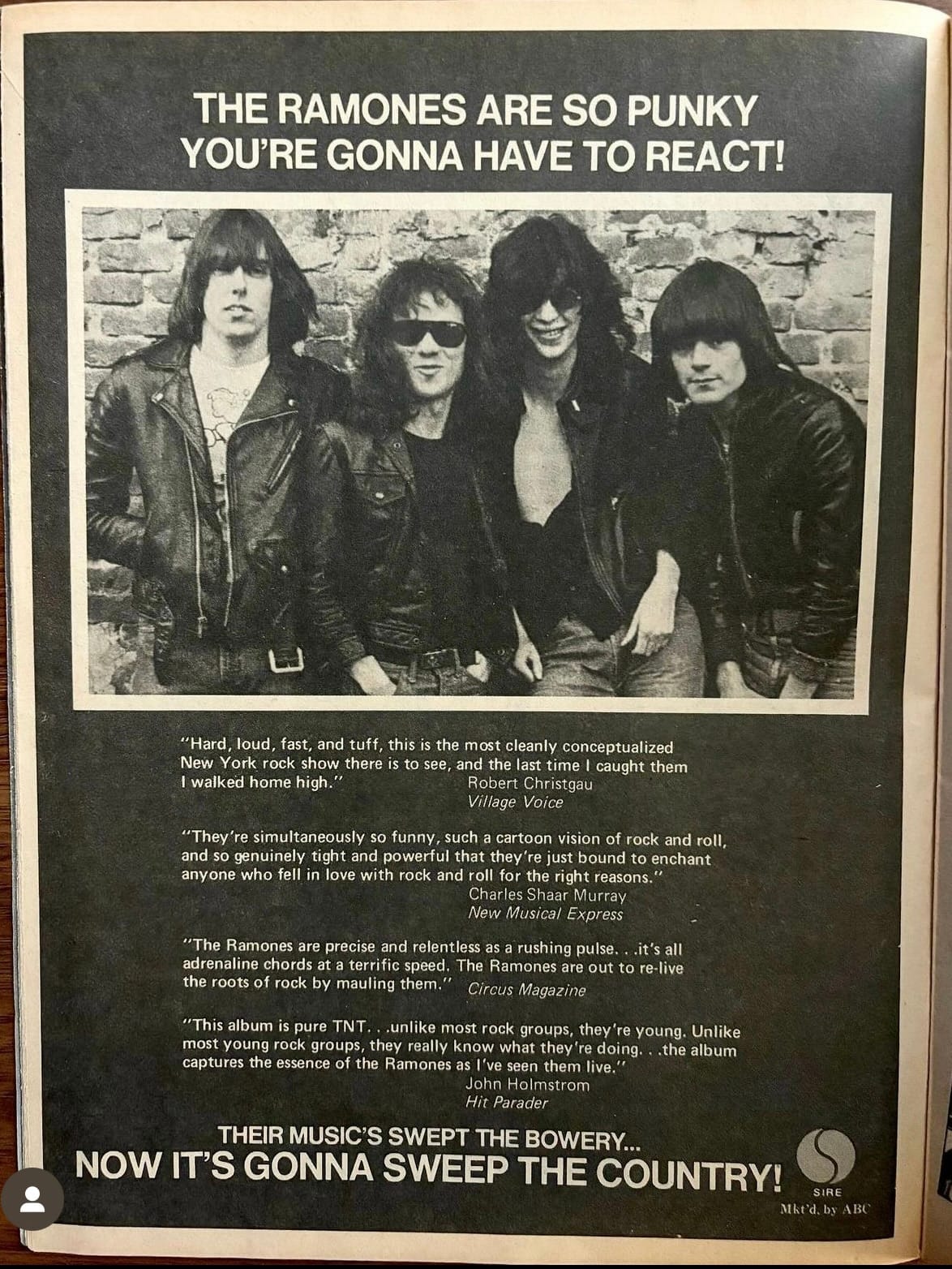 Vintage magazine advertisement featuring four band members in leather jackets against a brick wall, with critical quotes and promotional text below.