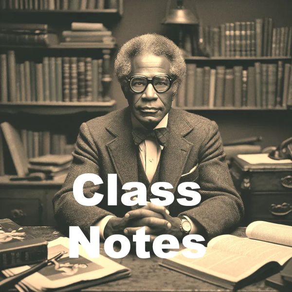 Older man with grey afro and glasses seated at desk with papers and books, bookshelves behind him, wearing brown suit jacket.