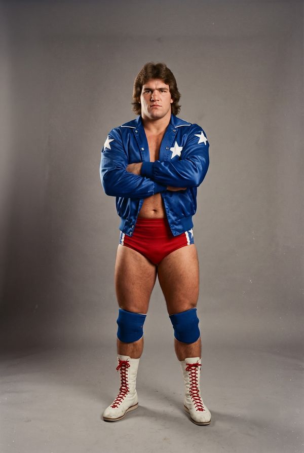 Rocket Roger Rush in a 1980 studio portrait, arms crossed, wearing a blue jacket with white stars over red trunks and white boots