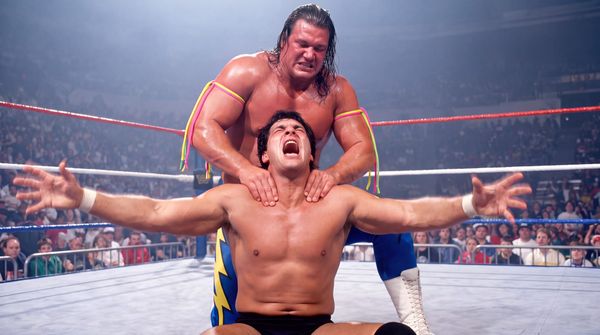 Vinnie Voltage applies the Power Surge, a two-handed nerve hold on the shoulders, to a seated opponent who throws his arms out and screams.