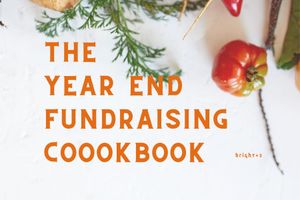 The Year End Fundraising Cookbook. The photo includes some spices, tomatoes, peppers and more. 