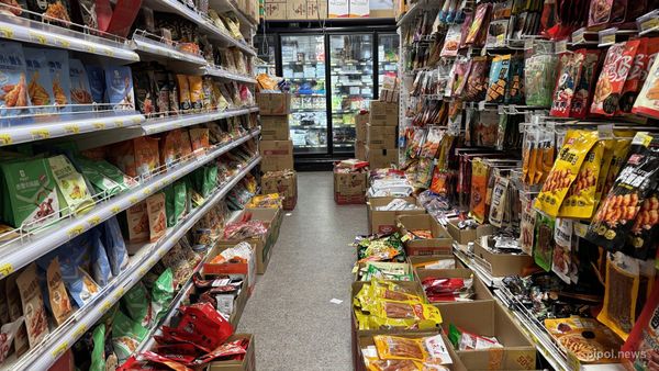 Pasillo de supermercado con estanterías de productos y carteles de precios