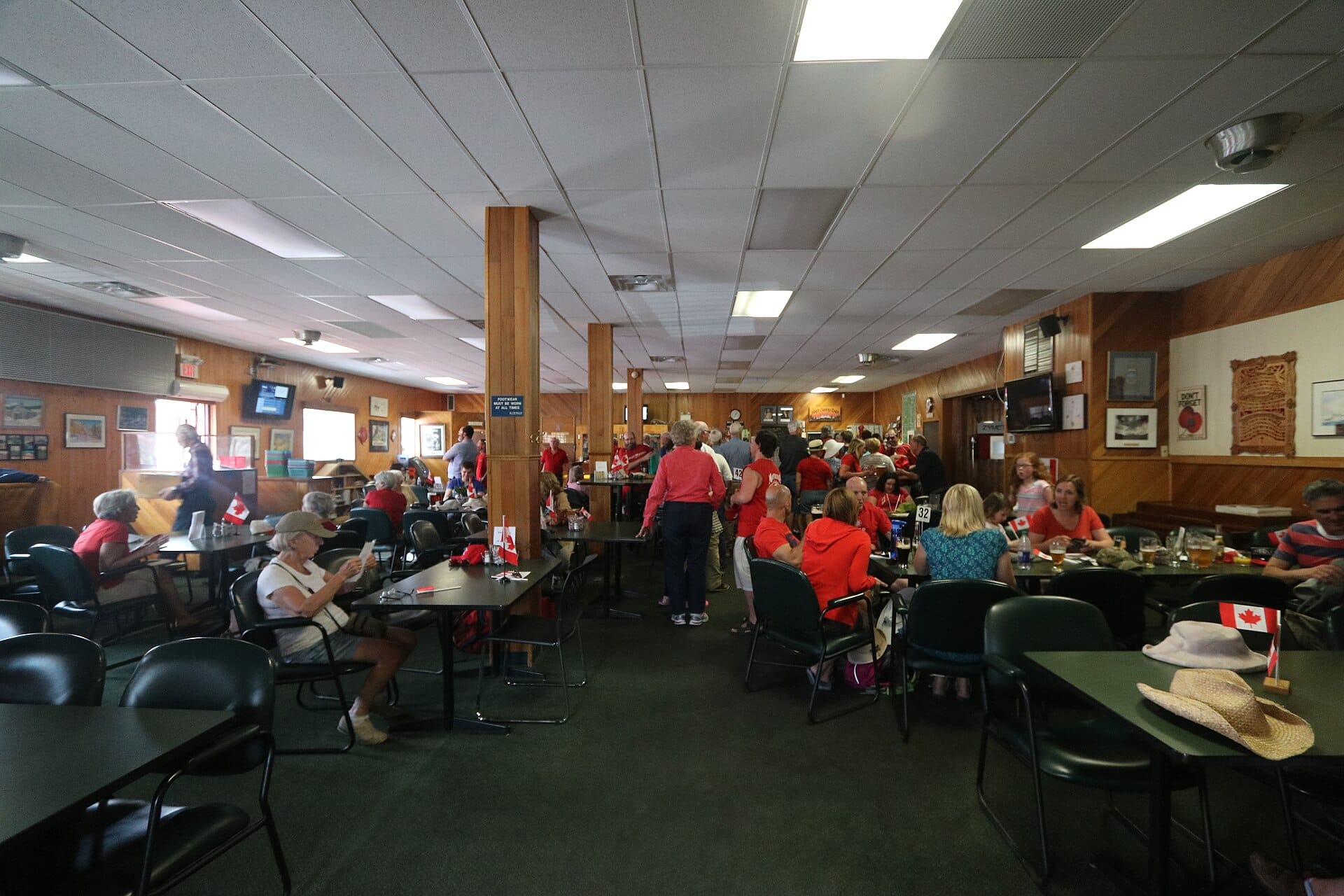 A busy restaurant dining room full of seated guests during a lunch rush