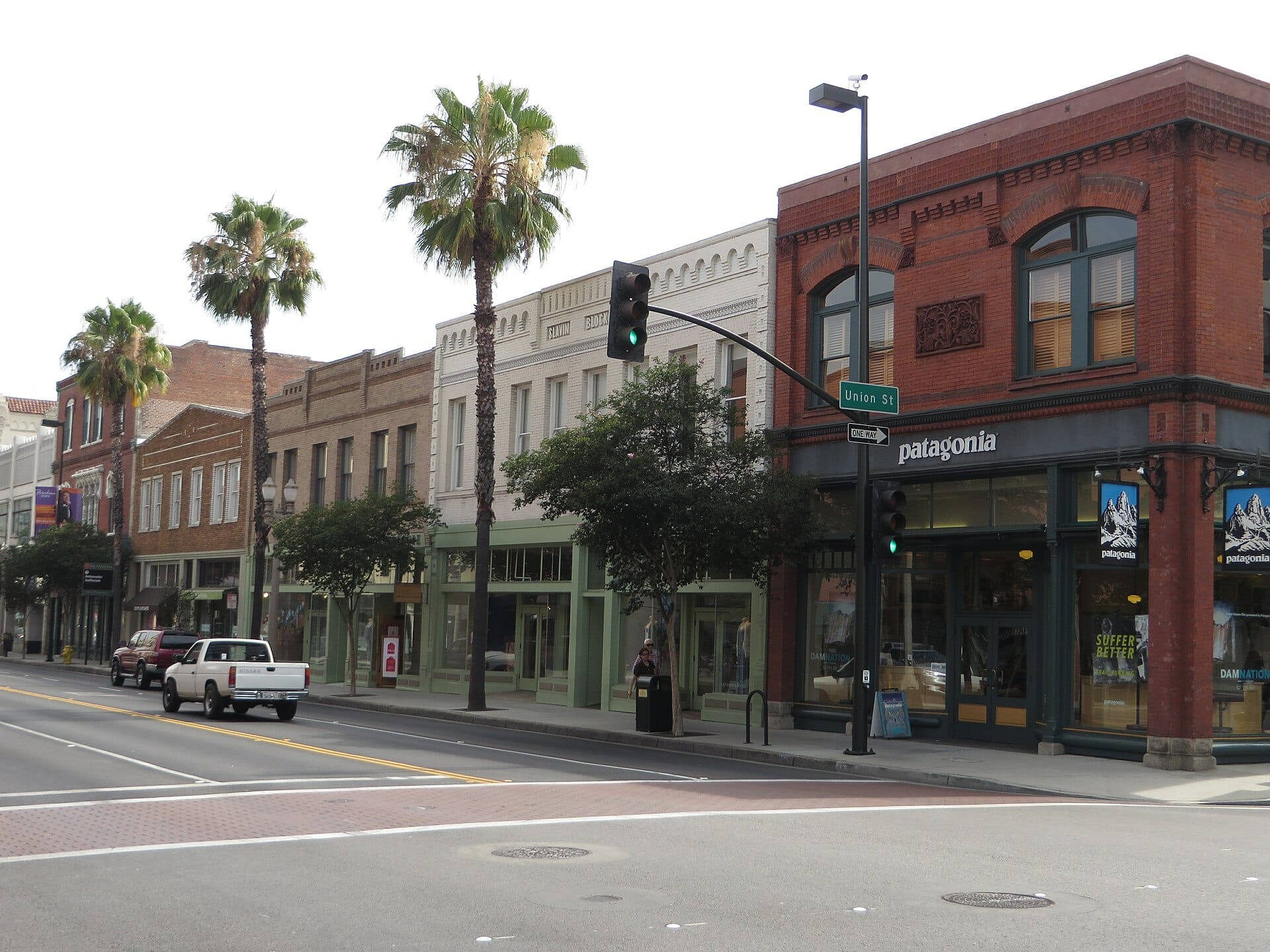 Pedestrians walking past retail storefronts on a shopping street