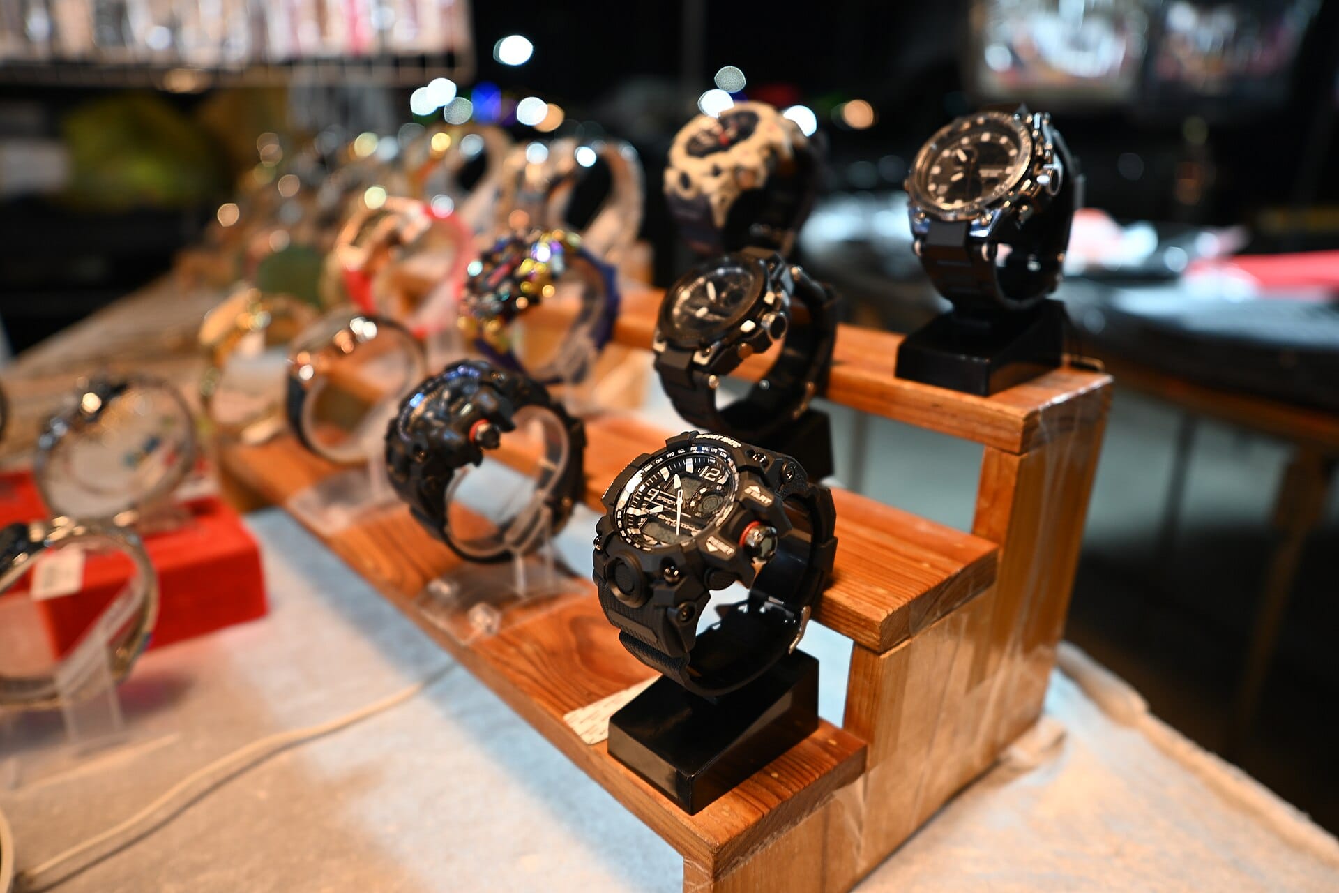 A row of wristwatches displayed on a wooden stand in a retail store