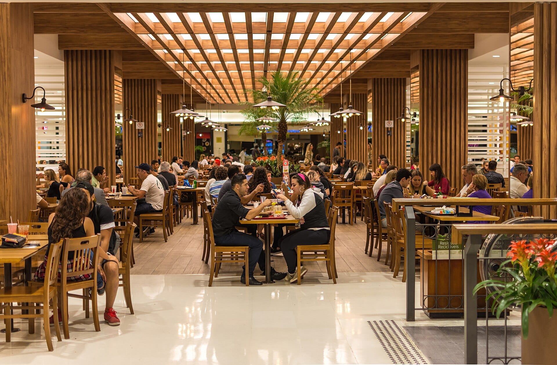 Shoppers walking through a modern multi-level shopping mall interior