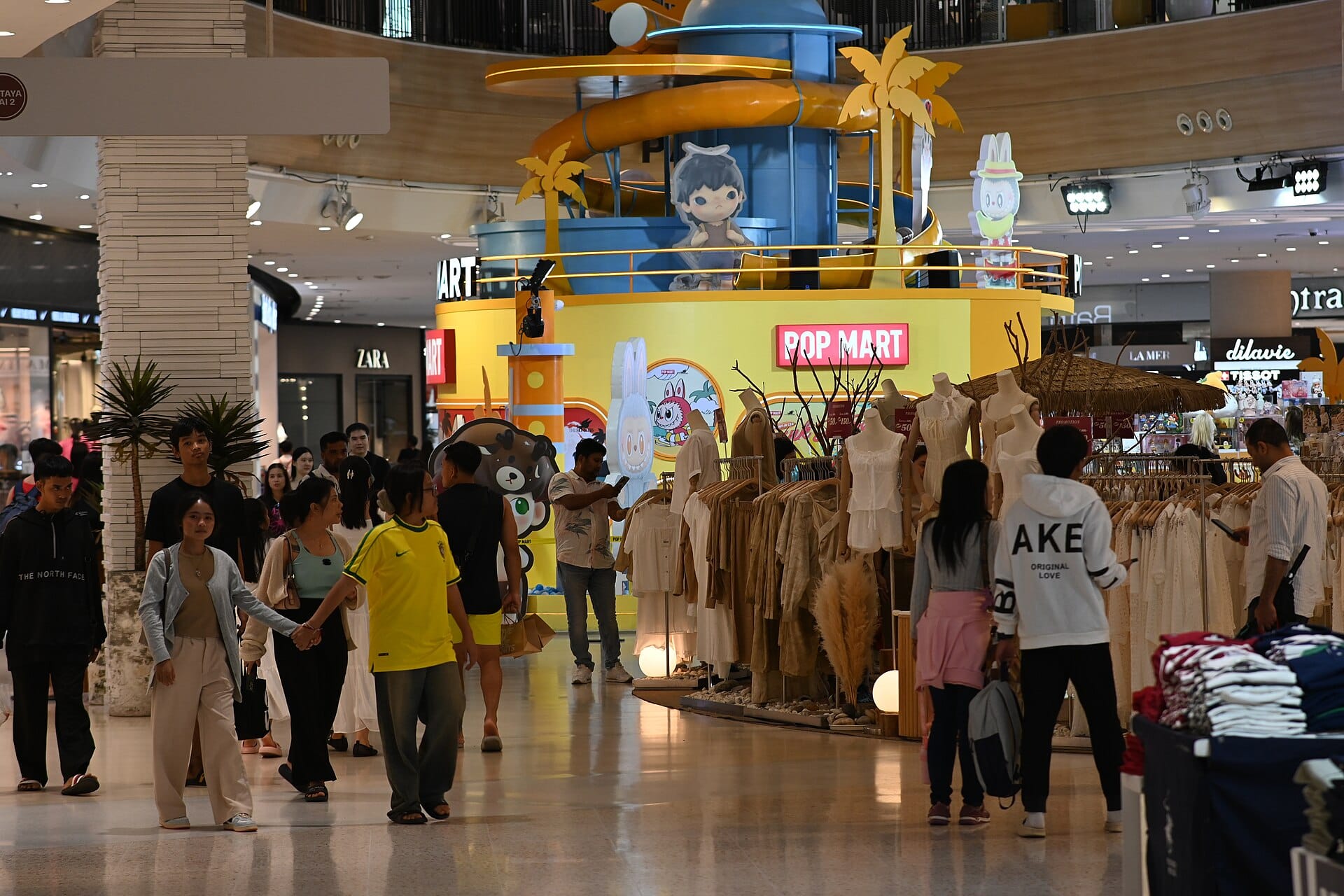 Shoppers browsing clothing inside a brightly lit retail store