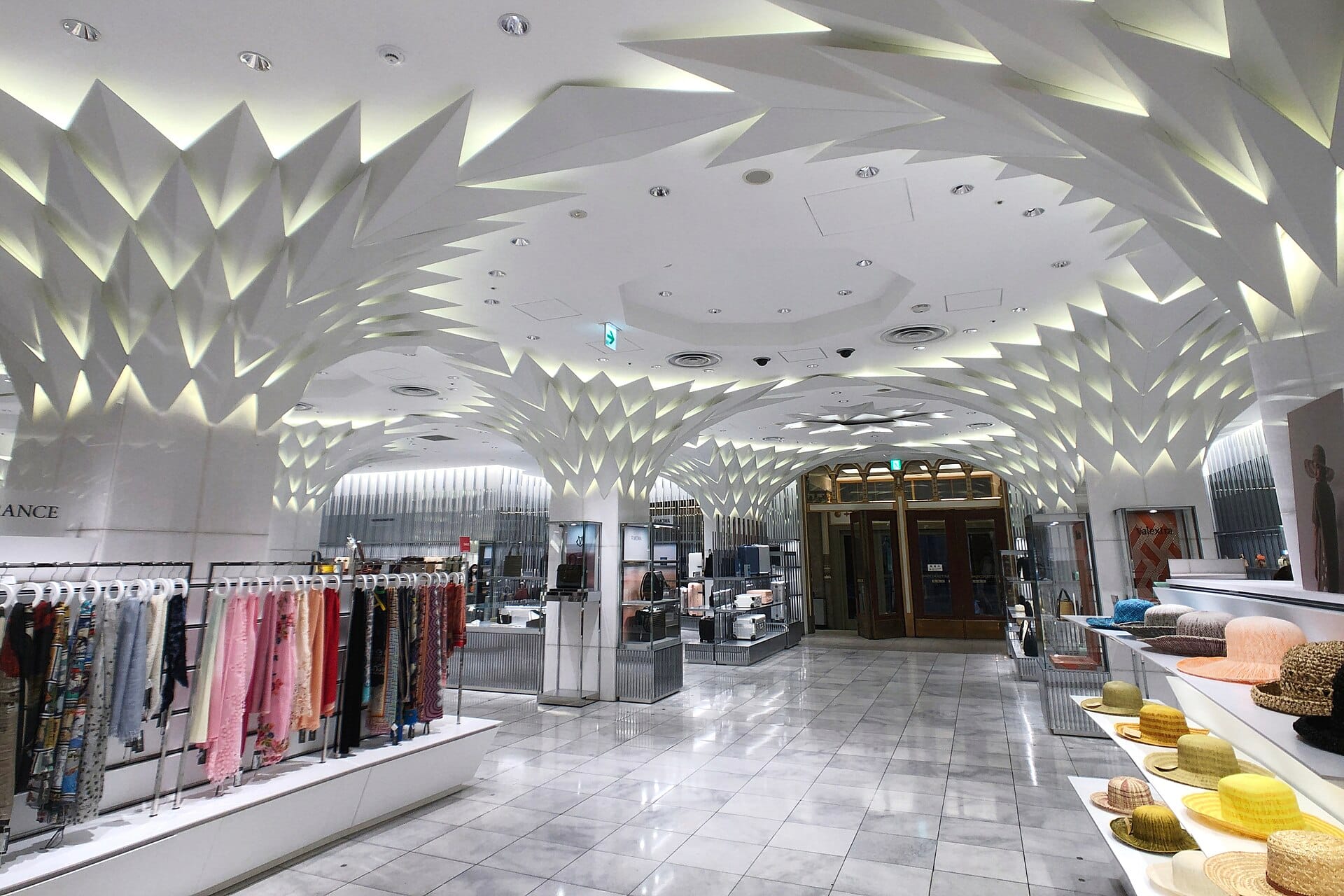 Interior of a large multi-floor department store with wide aisles and product displays.