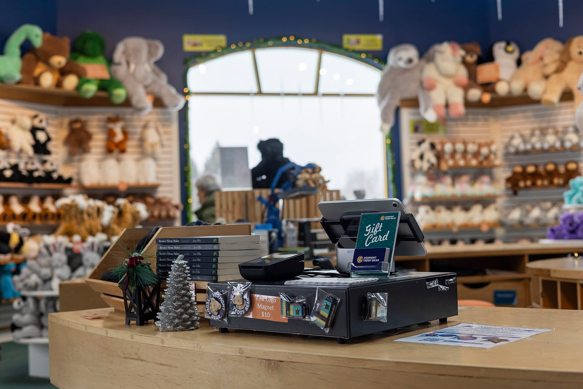 A modern retail checkout counter with a tablet point-of-sale system and gift card display.