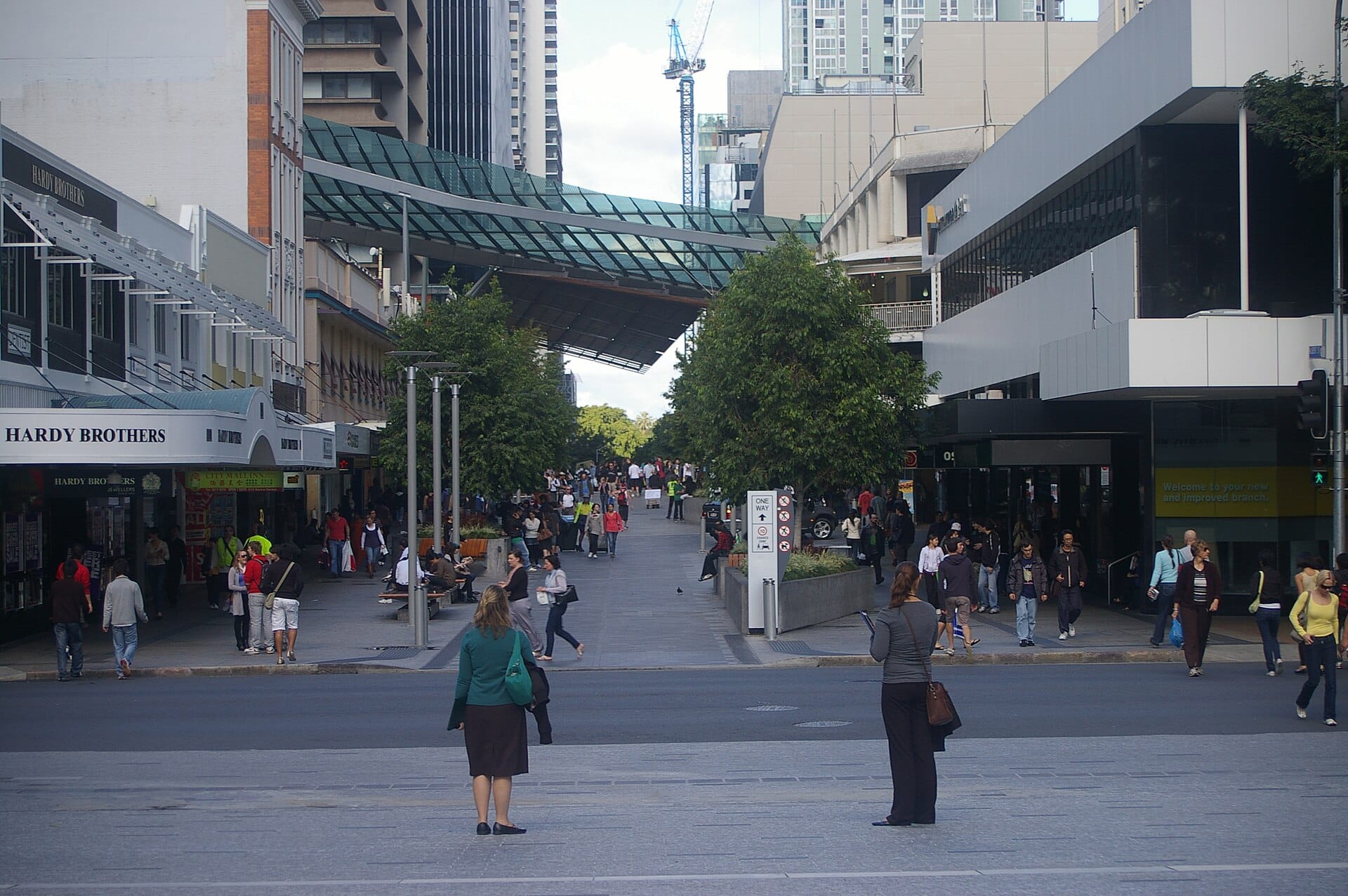 Shoppers walking through an open-air pedestrian retail area in a city center