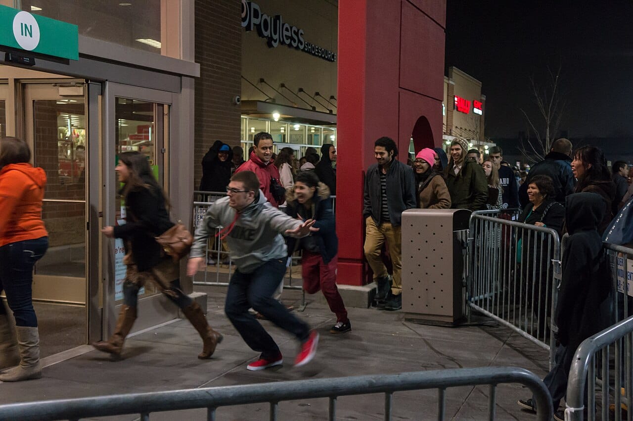Shoppers rushing through the entrance of a store on Black Friday morning