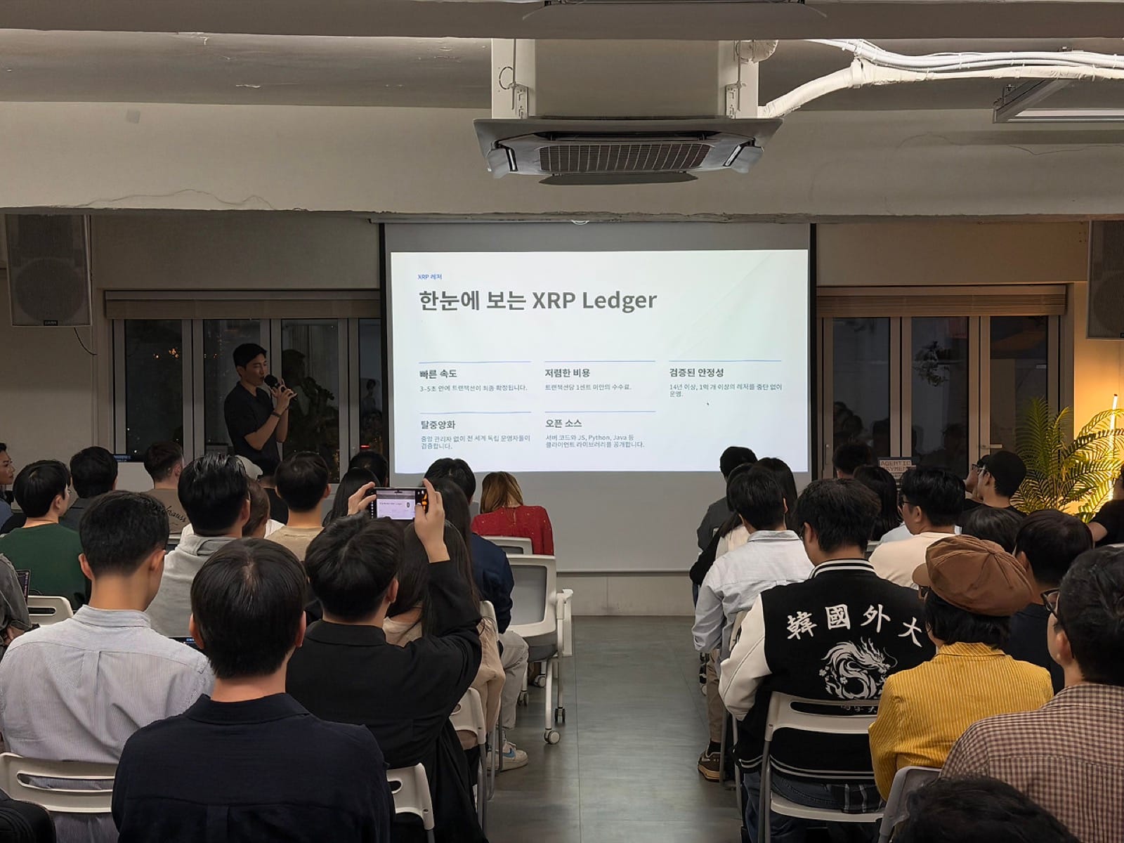 XRP Ledger 소개 슬라이드를 띄우고 발표하는 Ripple Joel Mun 님과 객석