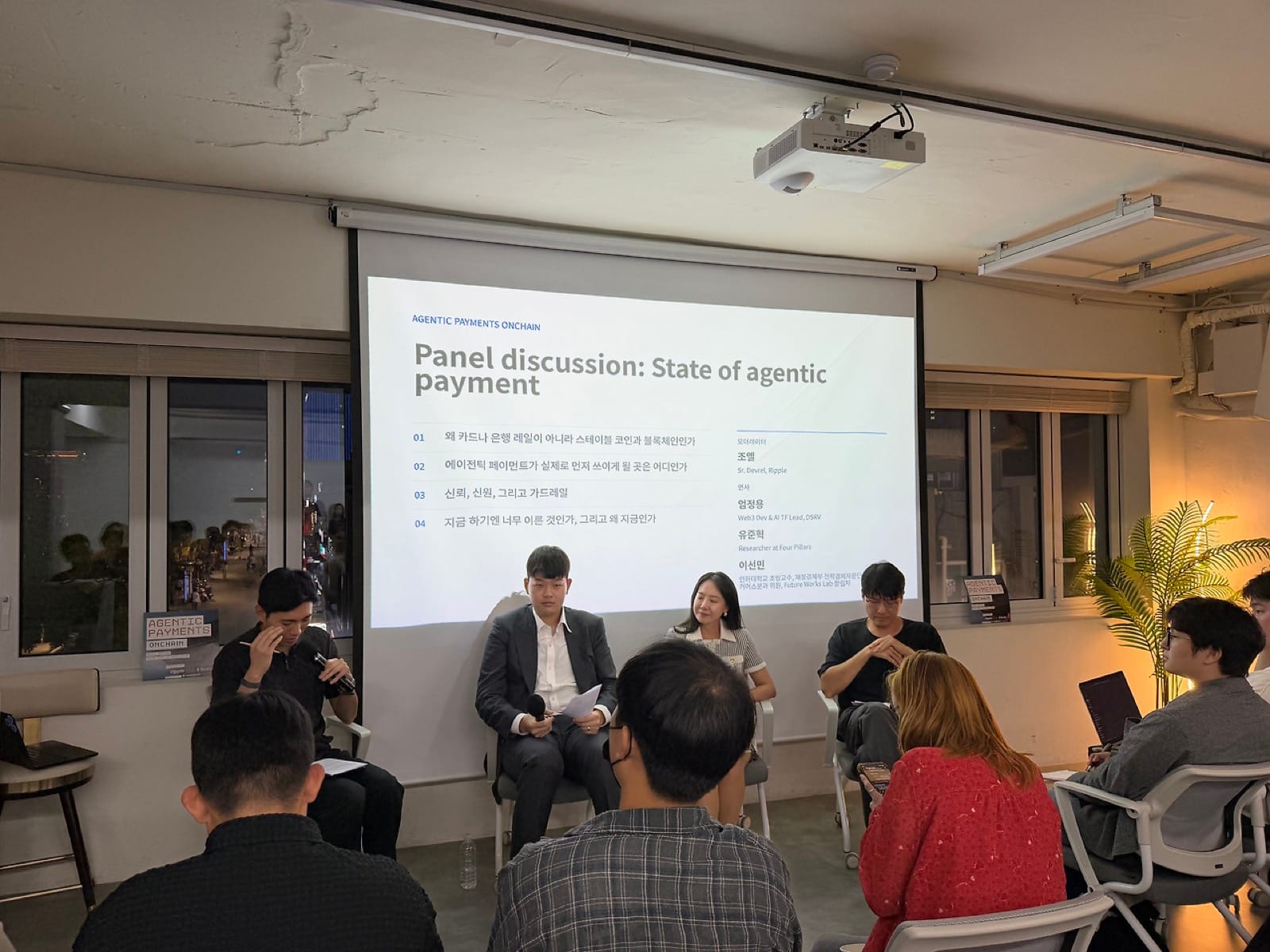 무대에 앉은 패널 네 명과 Panel discussion 슬라이드
