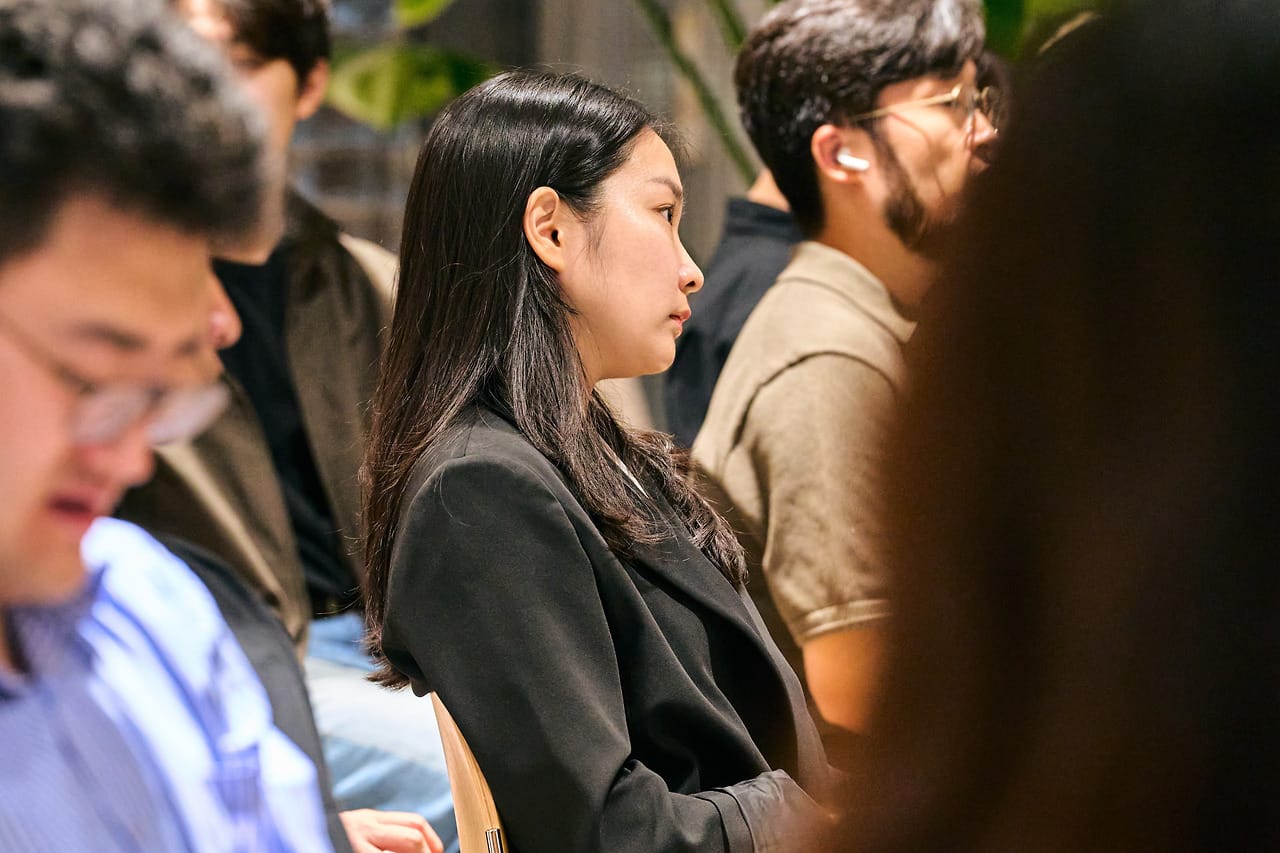 An attendee among the seated audience, eyes on the stage