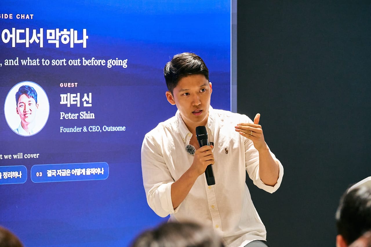 Close-up of Peter Shin of Outsome speaking into a mic