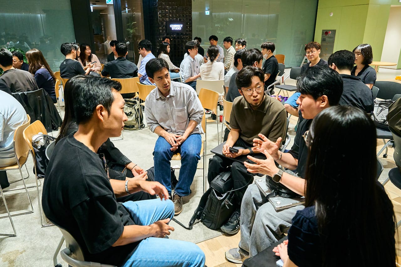 A roundtable group seated in a circle, deep in discussion