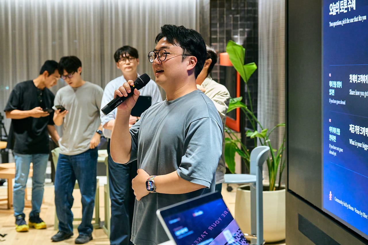 A table lead presenting his group’s takeaways with a mic