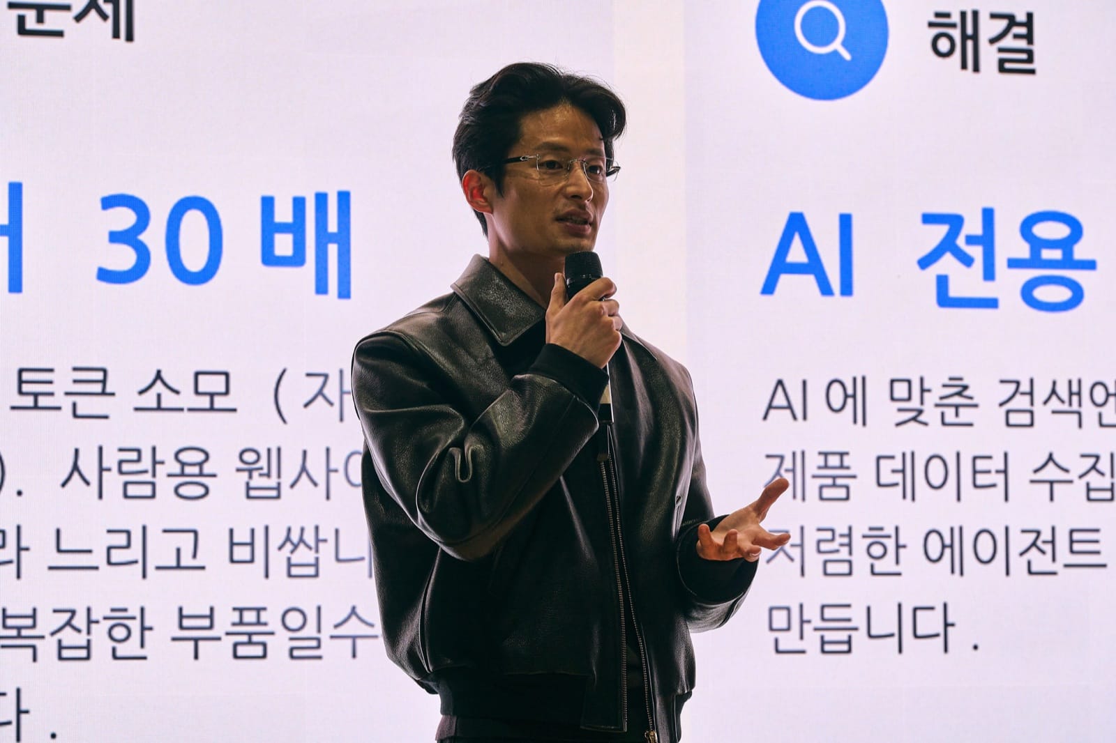 Arakyn's presenter pitching Agent Catalog in front of a slide about cutting token use by roughly 30 times