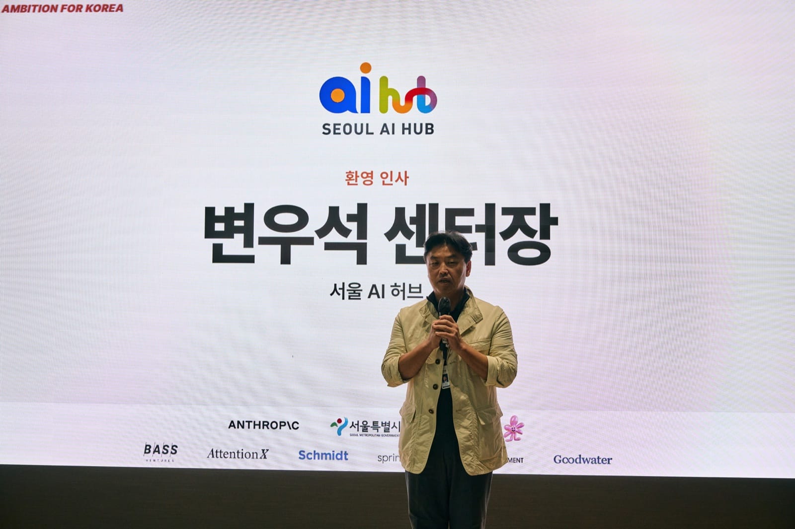 Seoul AI Hub director Wooseok Byeon giving welcome remarks in front of a slide with his name and the Seoul AI Hub logo