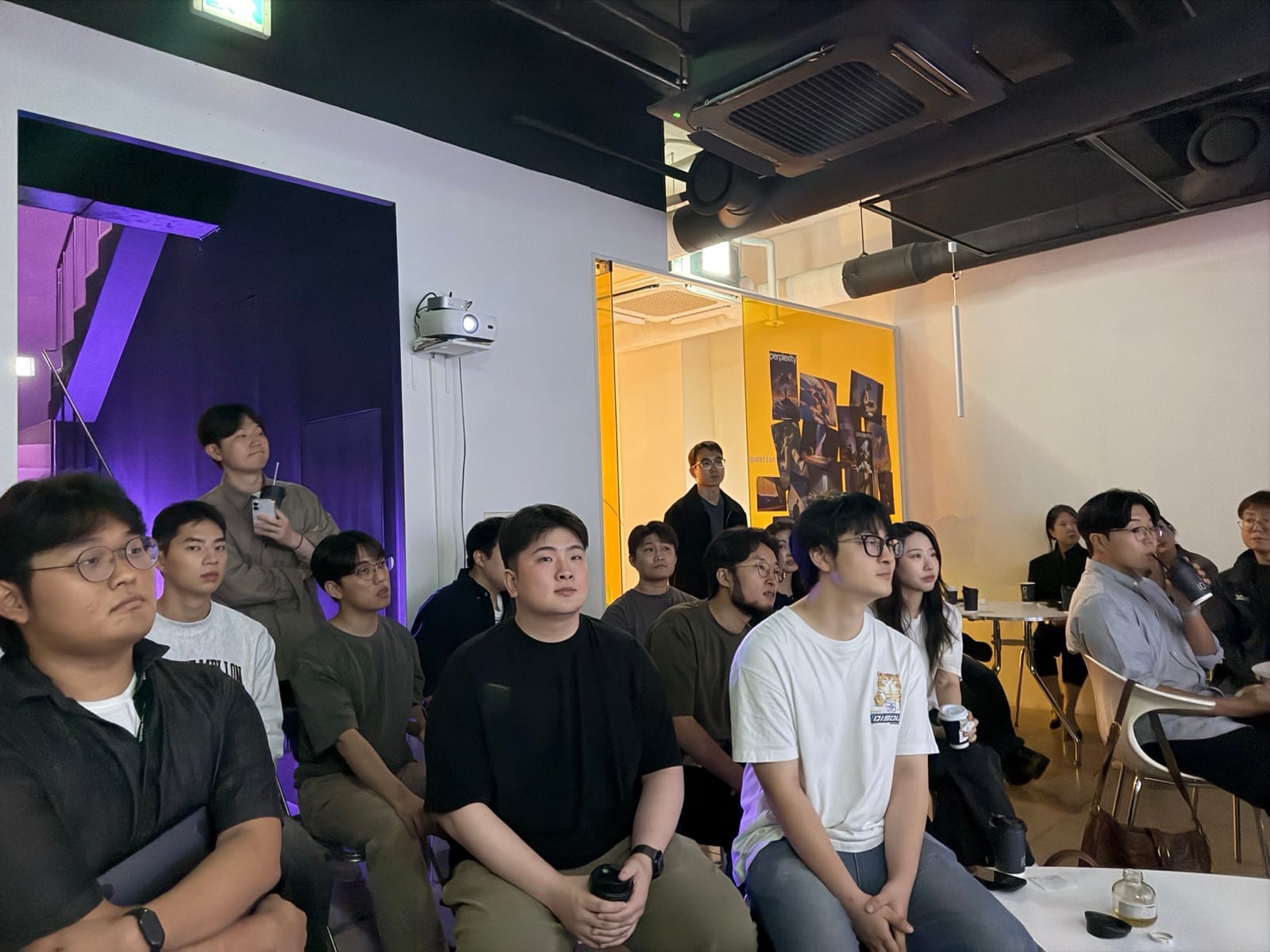 앞쪽을 바라보며 이야기를 듣는 참석자들