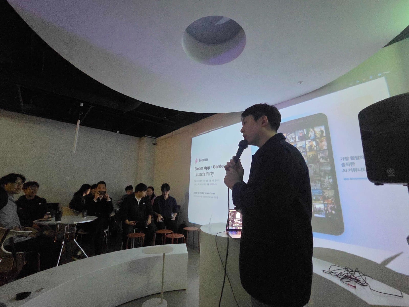 앱 화면을 띄워 놓고 마이크를 들고 설명하는 모습과 객석