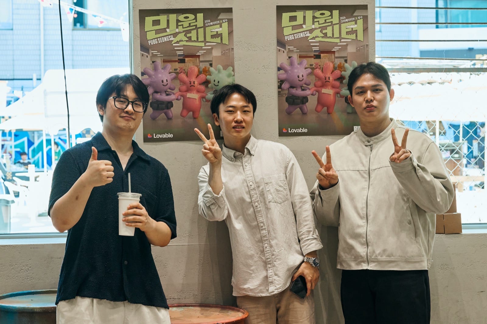 민원센터 포스터 앞에서 포즈를 취한 세 사람