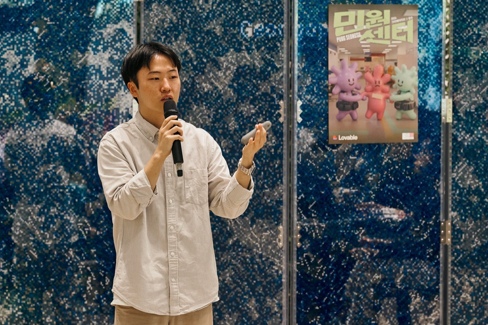 민원센터 포스터 앞에서 마이크를 들고 행사를 소개하는 김준수 님
