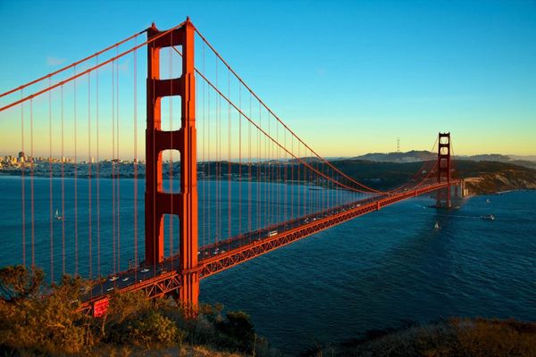 The Golden Gate Bridge in warm evening light, with San Francisco beyond it