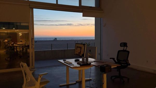 An empty desk facing the ocean at sunset