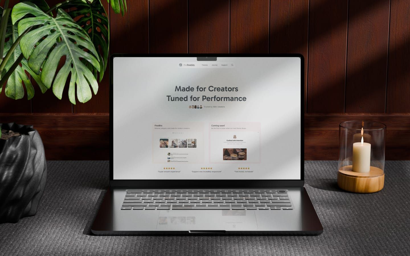 theFineBits Ghost theme studio website displayed on a MacBook in a cozy workspace with warm lighting