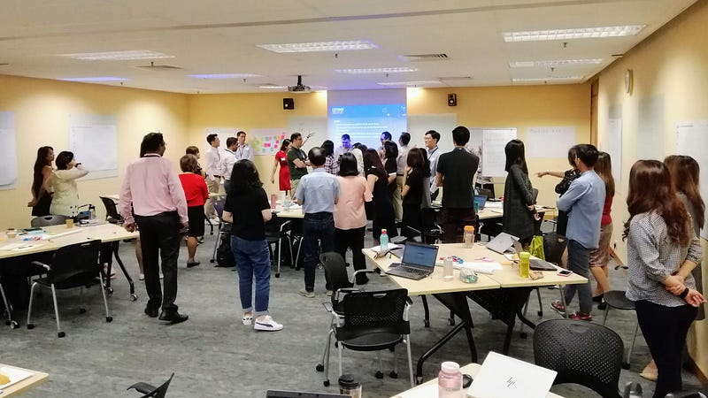Participants stand in relative to countries and regions of a world atlas map