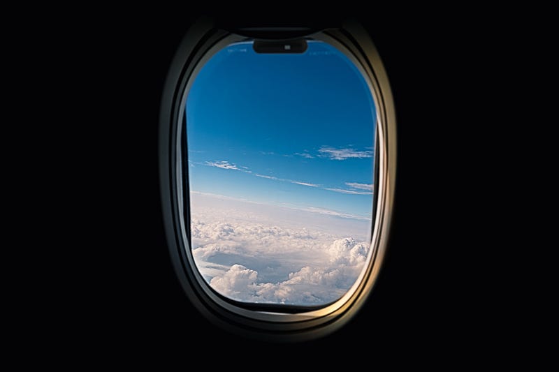 The picture shows the window of a plane with the blue sky in view, and a black silhouette all around. Staring out of the window without any connectivity may be what is needed for many designers