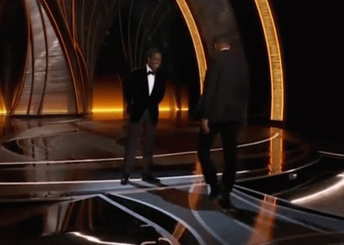 Will Smith walking up on stage to meet the presenter, Chris Rock, and gives him a huge slap