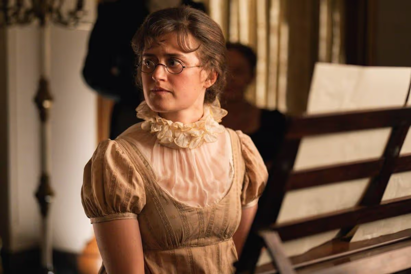 Ella Bruccoleri as Mary Bennet in "The Other Bennet Sister" sitting at the piano.