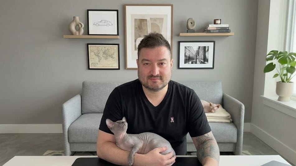 Tim Feeley and his two hairless cats (Boolean, in arms; Kevin, on couch)