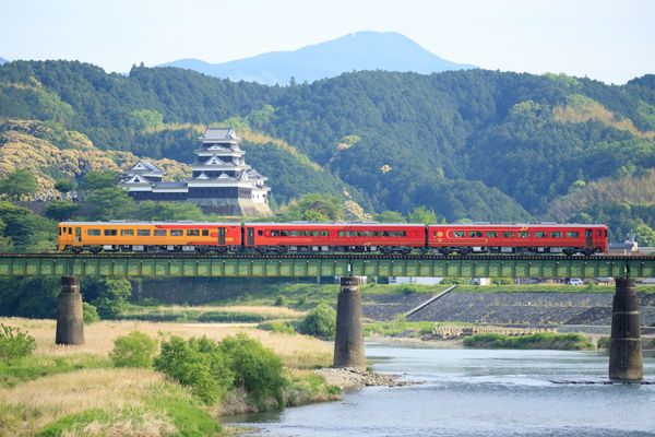 Der Touristenzug von JR Shikoku mit der Burg von Ozu im Hintergrund.