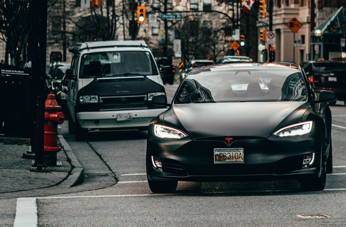 Tesla vehicle driving autonomously on a European city street representing Full Self-Driving approval and stock market reaction
